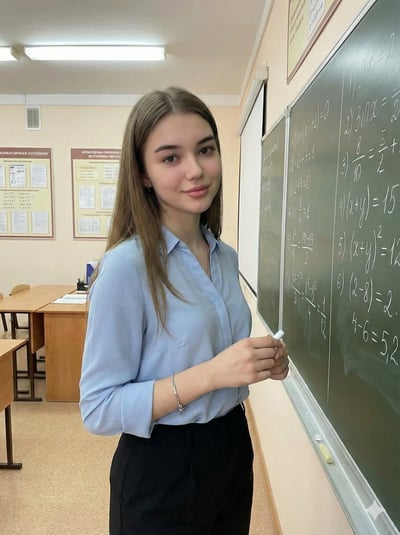 Modern Classroom Portrait of a Young Woman Holding Chalk Beside a Chalkboard thumbnail